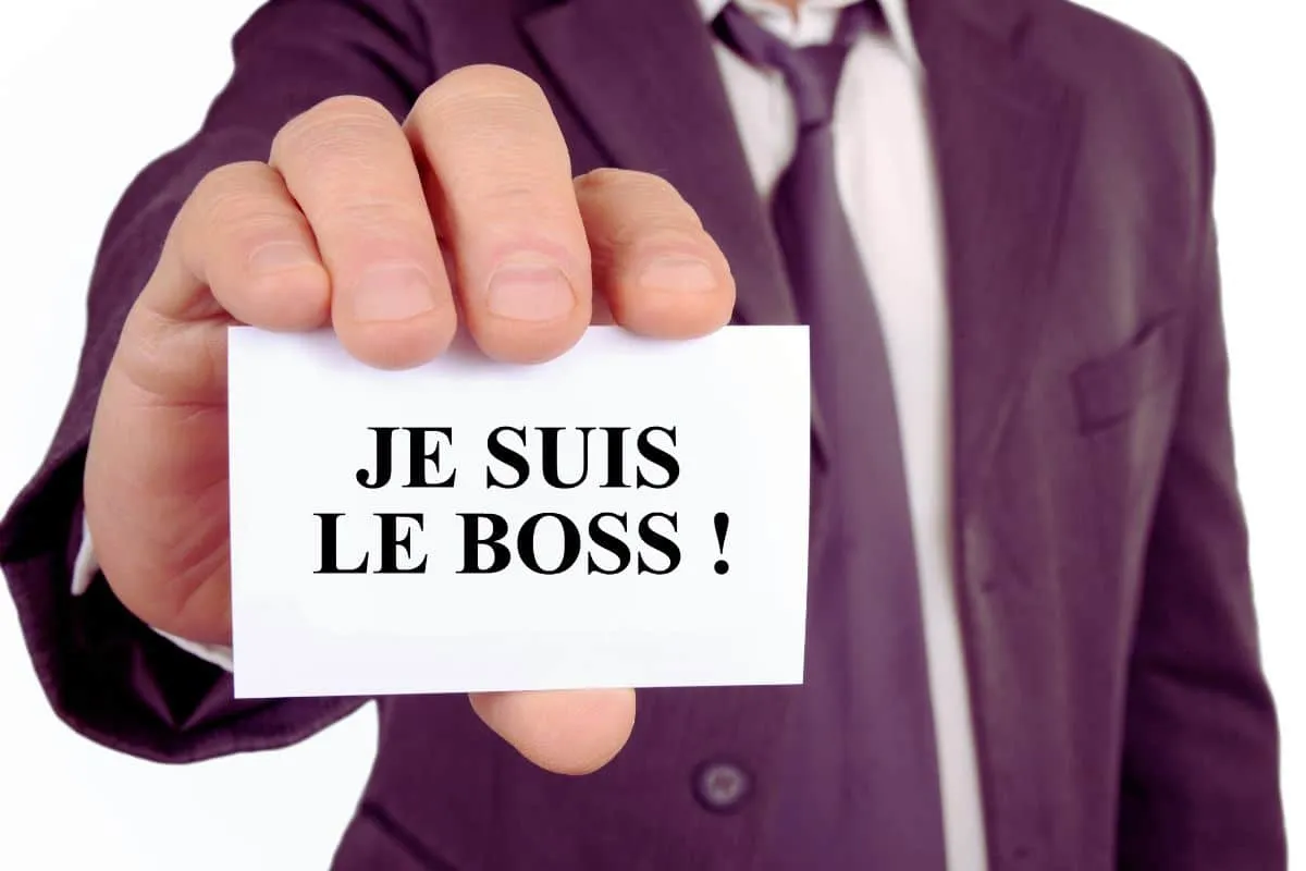 Homme tenant carte "Je suis le boss".