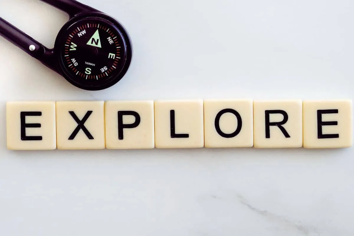 Boussole et mot EXPLORE en lettres blanches.