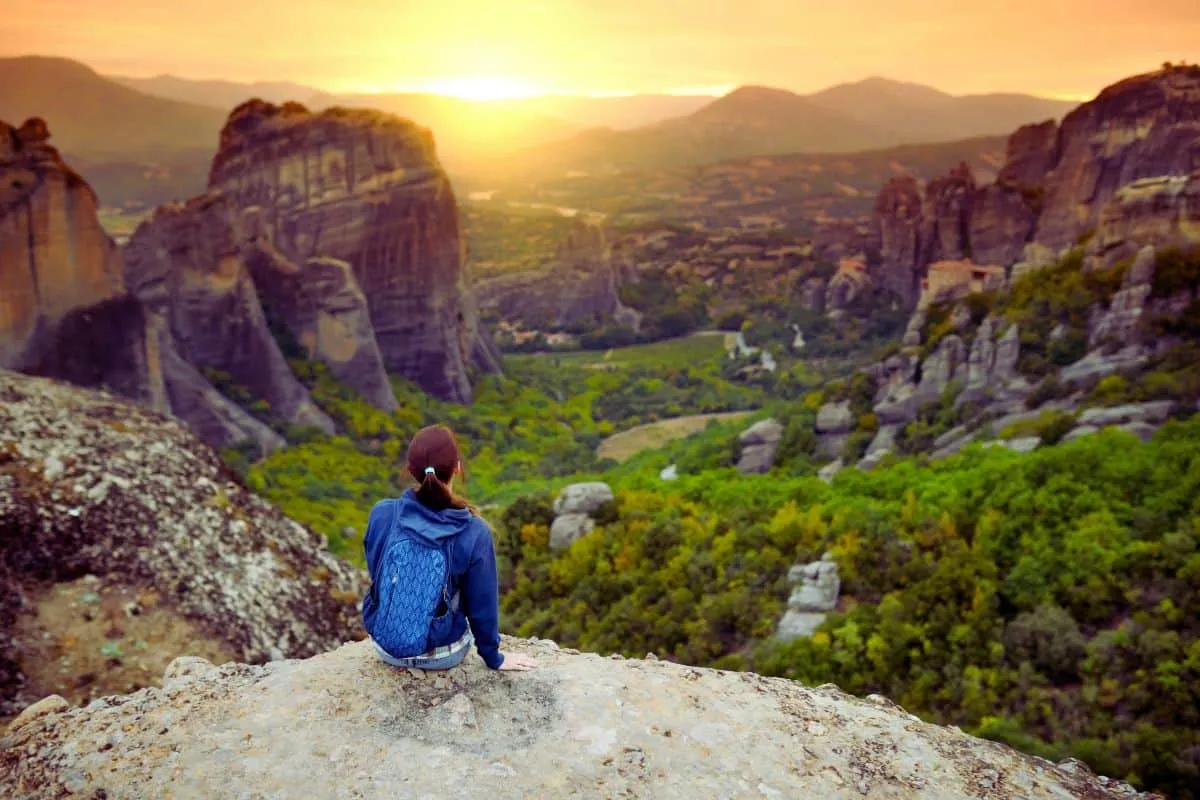 Personne admirant coucher de soleil en montagne